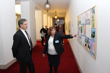 Min. Dienstbier si prohlíží vystavené obrázky z dětské výtvarné soutěže proti korupci