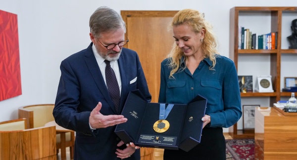 Tenistka Kateřina Siniaková premiéru Petrovi Fialovi ukázala zlatou olympijskou medaili ze smíšené čtyřhry v Paříži, 10. prosince 2024.
